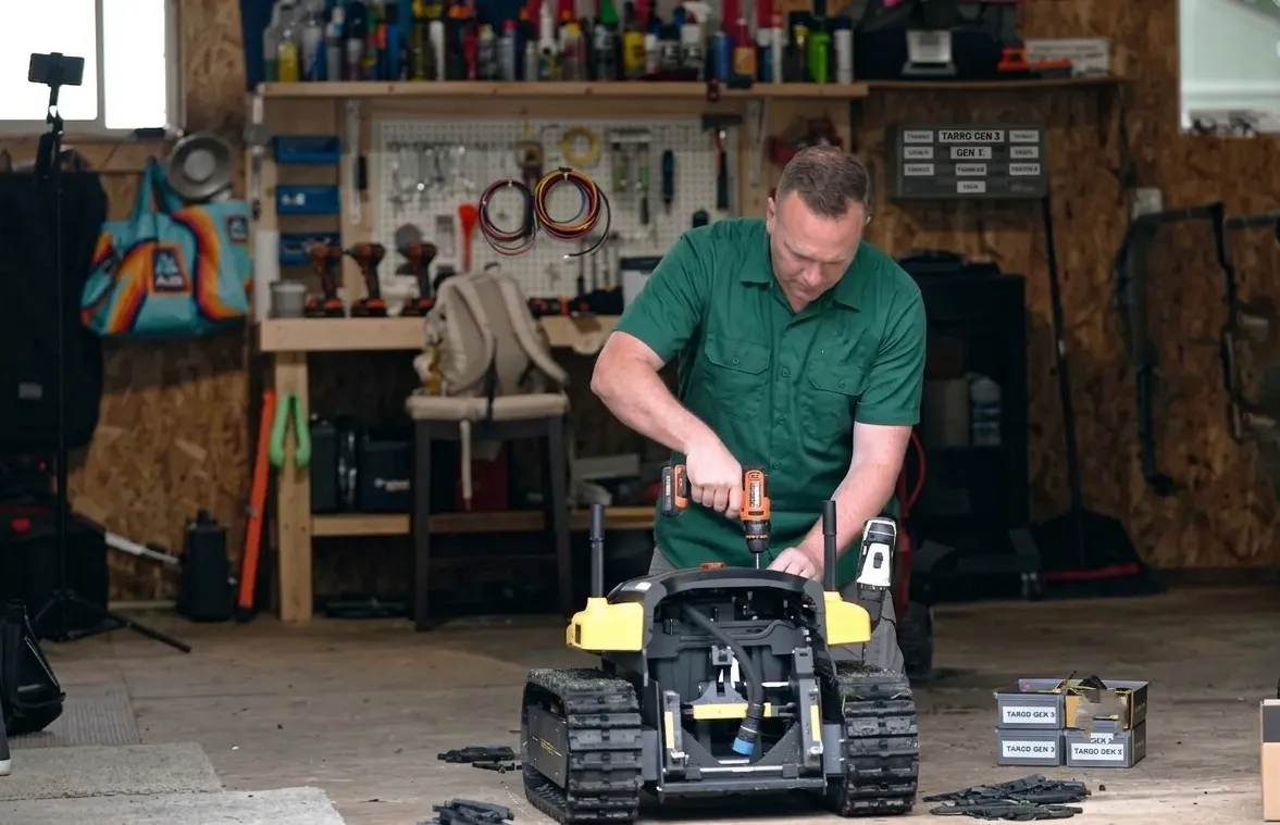 A Zippy crew member assembling a Yarbo Core with a drill in the workshop before an install